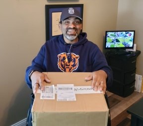 Pictured here opening a gift package from Blue H.E.L.P. is Officer Santos Cortez, who was paralyzed after being struck by a drunk driver. (Photo/Blue H.E.L.P.)