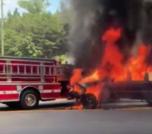 The video shows an on-fire pickup truck – that’s also towing a camper trailer – roll downgrade toward the fire truck and ultimately come to rest against the fire apparatus. (Photo/Facebook)