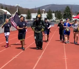 Upon crossing the finish line, firefighter Ryan Robeson was swarmed by medical personnel, who quickly removed his gear and gave him water, Gatorade and cold towels. (Photo/Screenshot)