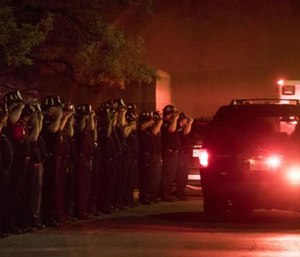 Chicago Fire Department and Chicago Police personnel salute as a procession of emergency vehicles including the ambulance carrying the body of Chicago fire department diver Juan Bucio. (Ashlee Rezin/Sun Times via AP)