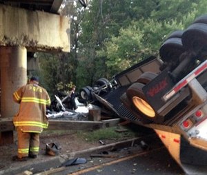 The wrecked tractor trailer lies under an overpass from which it fell Friday; the driver was killed and no one else was injured. (Assistant Fire Chief Alan C. Doubleday/Prince George’s County, Md. Fire Department via AP)