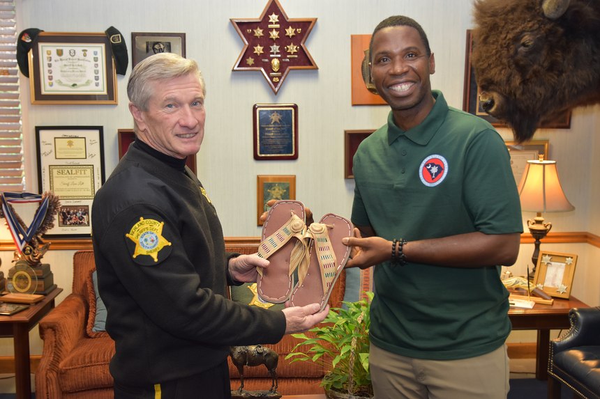 RCSD Senior Deputy Thomas Browne presents handmade house slippers to Sheriff Leon Lott.