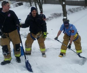 EMS, police, and fire clearing snow off a roof after the homeowner collapsed and later died (Officer Bernie Hallums/Manchester Police Department)