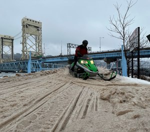 Snowmobilers cross the Portage Canal using the Portage Lake Lift Bridge running between Hancock and Houghton, Michigan.