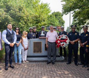 Ed Corbin, brother of the late Leonard Corbin, Springfield's first African-American firefighter, nephew Jason Corbin and his wife Altina Corbin, niece Renee Corbin joined by Springfield mayor Domenic J. Sarno, Springfield police deputy chief Rupert Daniel, and Springfield firefighters for a photo in front of the Leonard A. Corbin memorial at Mason Square Fire Station