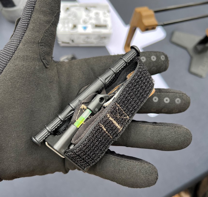 The ETQ (Everyday Carry Tourniquet) Tourniquet from Snakestaff Systems is a keychain-sized TQ with a full-sized textured windlass and a carabiner closure. The yellow item in the photo is an attached chemlight.