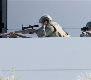 A Tucson Police sniper and a spotter watch a man in the parking lot of the Tucson Police Flowing Wells substation.