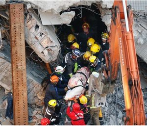 Emergency rescuers remove a body found in a collapsed building from an earthquake in Taiwan, Sunday. (AP Photo/Wally Santana)