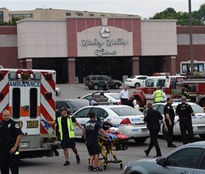 Dozens of law enforcement and emergency responders work in the parking lot after a suspect wielding a hatchet and gun inside a Nashville-area movie theater died after exchanging gunshots with SWAT team members that stormed the theater, police said, Wednesday. (AP Photo/Mark Zaleski)
