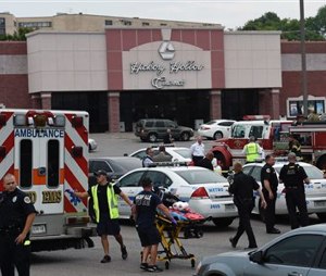 Dozens of law enforcement and emergency responders work in the parking lot after a suspect wielding a hatchet and gun inside a Nashville-area movie theater died after exchanging gunshots with SWAT team members that stormed the theater, police said, Wednesday. (AP Photo/Mark Zaleski)
