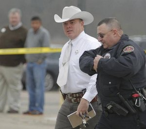 Texas Ranger Don Stoner with officers of the Burleson Police Department conduct an investigation at the scene of a bank robbery and shooting on December 19th, 2015.