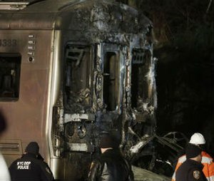 Emergency personnel work at the scene of a Metro-North Railroad passenger train and vehicle accident in Valhalla, N.Y., Tuesday, Feb. 3, 2015. A packed commuter train slammed into a sport utility vehicle stuck on the tracks and erupted into flames, authorities said. (AP Photo/Seth Wenig)
