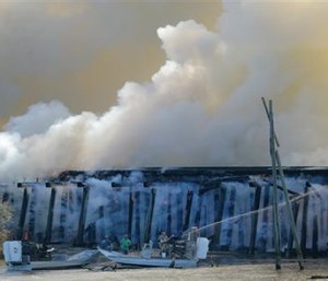 A fire burns on a train trestle parallel to Interstate 10 near the Bonnet Carre Spillway, west of New Orleans on Saturday. (Brett Duke/NOLA.com The Times-Picayune via AP)