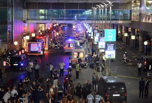 Medics and security members work at the entrance of the Ataturk Airport after explosions in Istanbul, Tuesday, June 28, 2016.