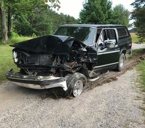 The black Ford pickup truck damaged in a rear-end crash near Lake Leelanau. An ambulance crew discovered the crash and investigators later arrested two men on suspicion of operating a vehicle while intoxicated. (Photo/Tribune News Service)