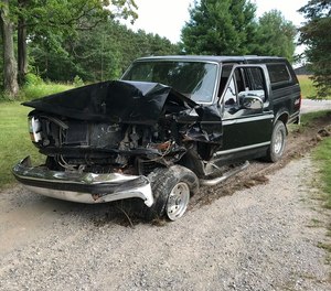 The black Ford pickup truck damaged in a rear-end crash near Lake Leelanau. An ambulance crew discovered the crash and investigators later arrested two men on suspicion of operating a vehicle while intoxicated.