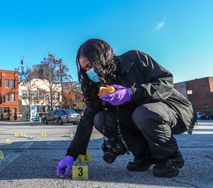 Atlanta Police Crime Technician K. Gallagher collects dozens of shell casings following a shooting outside a downtown Atlanta hookah lounge on Nov. 30, 2020.