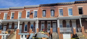 An early morning rowhouse fire killed three children and left a woman in critical condition.