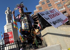 Andrew Thompson of the Choctaw Nation of Oklahoma brings his dance down the steps at the statue of Christopher Columbus at a rally for Indigenous Peoples' Day on Fri., Nov. 29, 2019. Image: Karl Merton Ferron/Baltimore Sun via TNS