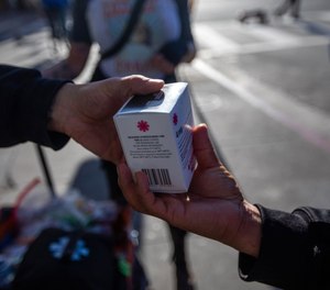 Volunteers from The Sidewalk Project hand out boxes of Narcan spray used for opioid overdoses in skid row on Tuesday, Jan. 31, 2023, in Los Angeles.