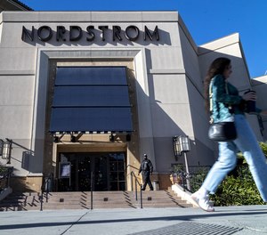 A security guard patrols the front entrance of Nordstrom on Nov. 23, 2021, after an organized group of thieves attempted a smash-and-grab robbery late Nov. 22 at The Grove location in Los Angeles.