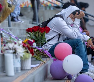 Johann Hervert, 18, sits next to a memorial on the steps outside Helen Bernstein High School on Sept. 16, 2022, in Los Angeles after a fentanyl-laced pill led to the overdose death of a 15-year-old student.