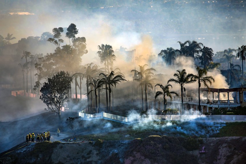 Firefighters worked as homes continued smoldering Thursday in Laguna Niguel.