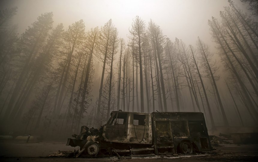 Burned trees rise above a truck destroyed by the Dixie Fire in the town of Greenville. 