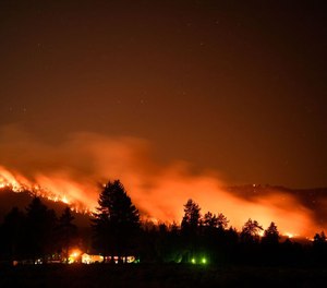 Trees burn on a hillside behind Honey Lake campground during the Dixie Fire on August 18, 2021 in Milford, California.