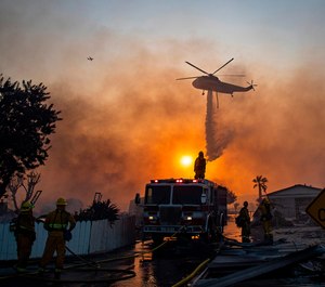 A helicopter drops water on burning mobile homes to try and keep the Sandalwood fire from spreading at Villa Calimesa mobile home park on Thursday, Oct. 10, 2019, in Calimesa, Calif. (Gina Ferazzi/Los Angeles Times/TNS)