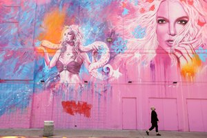 A woman, masked against COVID-19, walks past a building that features the image of Britney Spears at a shopping center in the Fairfax District in Los Angeles on May 18, 2020. Image: Genaro Molina/Los Angeles Times via TNS