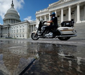 A U.S. Capitol Police officer rides a motorcycle past the U.S. Capitol on Sept. 11, 2023, in Washington, DC.
