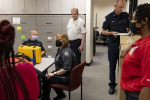Jennifer Garross (center) a mental health clinician, meets with other members of Chicago's Crisis Assistance Response and Engagement team, including police officers and paramedics, on July 14, at the start of their workday.