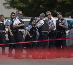 Chicago police officers work at the scene where an officer was shot and wounded Sunday, June 5, 2022, in the Englewood neighborhood of Chicago.