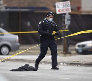 Chicago police officers work at the scene of a mass shooting that left 15 people shot, two fatally.
