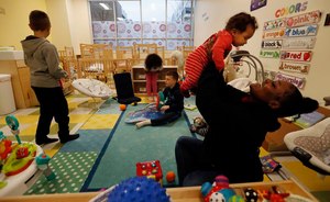 Te'Andra Turnage plays with 3-month-old Logan Yockey-Monroe at a childcare facility in Ohio. Starting late last month, childcare centers in Ohio can only be permitted to operate under a temporary pandemic license, serving children from families who work in healthcare, safety and other 