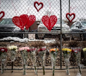 Flowers are seen at a fence outside the location where a gunman opened fire at King Soopers grocery store on Monday on March 23, 2021, in Boulder, Colorado. Ten people were killed in the attack.