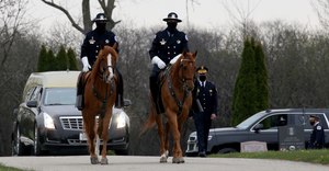 Mounted police officers escort the hearse in during the funeral services for Chicago police Officer Ronald Newman at Lincoln Cemetery in Blue Island, April 23, 2020. Newman, 59, is the third Chicago police officer who has died from complications stemming from COVID-19. Image: Antonio Perez/Chicago Tribune