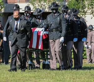 Florida Highway Patrol Honor Guard escort the casket of Trooper Lazaro R. Febles at Woodlawn Park Cemetery in southwest Miami-Dade on Friday, August 20, 2021. Febles served more than 11 years with the Florida Highway Patrol in Troop E Miami, he died of complications from COVID-19. (