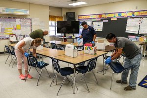 Austin district custodians deep clean Galindo Elementary School in March amid the coronavirus outbreak. The school district spent $7 million in the first six weeks after schools shuttered in coronavirus-related expenses like disinfecting building, protective equipment and purchasing technology for online learning. Image: Lola Gomez/American-Statesman via TNS