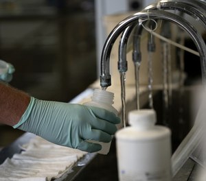 A geologist with the Illinois Environmental Protection Agency collects samples of treated Lake Michigan water in a laboratory at the water treatment plant in Wilmette, Illinois, on July 3, 2021.