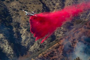 An air tanker drops fire retardant on a slow-moving 45-acre brush fire above Glen Helen Parkway on Dec. 26, 2020, in Lytle Creek, California.