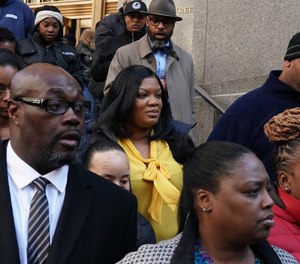 In this photo from Nov. 25, 2019, Metropolitan Correctional Center guard Tova Noel (yellow shirt) surrounded by supporters leaves Federal Court in New York City. Noel and another guard had been charged with falsifying prison records on the night Jeffrey Epstein died.