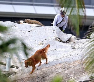 Fire rescue personnel conduct search and rescue with dogs in the rubble at Champlain Towers South Condo in Surfside, located at 8777 Collins Avenue, a part of which collapsed in the early morning in Surfside, Florida, Thursday, June 24, 2021.