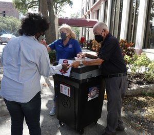A woman drops off her election ballot at the Pinellas County Supervisor of Elections office in downtown St. Petersburg, Florida, on Oct. 29, 2021.