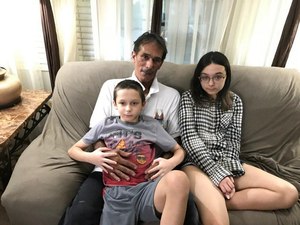 Darry Tunick with the two youngest of his four children. A single father, Tunick is struggling with depression after losing his job due to cornoavirus and being unable to obtain unemployment benefits for months. Image: Jorge Millian/Palm Beach Post via TNS
