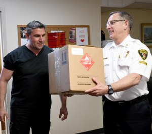 Rosario Carcione, pharmacy manager at Compounding Pharmacy of Green, drops off donated hand sanitizer to Canton City Fire Chief Tom Garra on Monday to help keep the department safe during the coronavirus pandemic. Monday, April 6, 2020.