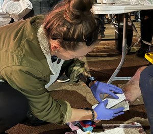 In Philadelphia's Kensington neighborhood, Stephanie Klipp, a wound care nurse, works to bandage a serious xylazine wound in danger of reaching this man's bone.