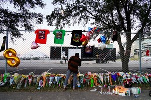 A visitor wrote a note Sunday at a memorial outside of NRG Park, the site of the Astroworld tragedy in Houston.