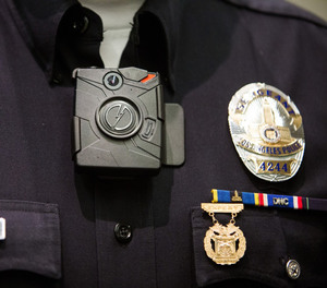 An LAPD officer wears a Taser Axon on-body camera during a press conference last December.